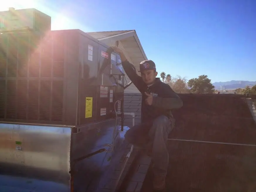 HVAC technician performing AC Tune-Up on a rooftop unit in Winthrop Harbor